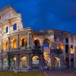 The Colosseum illuminated against a deep blue evening sky