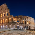 The Colosseum floodlit at night, seen from the piazza